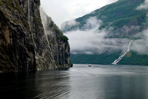 Fähre im Geirangerfjord mit Wasserfall