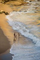 Kinder spielen am Strand in den Wellen in Portugal