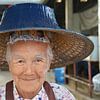 Portrait d'une dame avec un chapeau de paille bleu au marché Thaïlande sur My Footprints