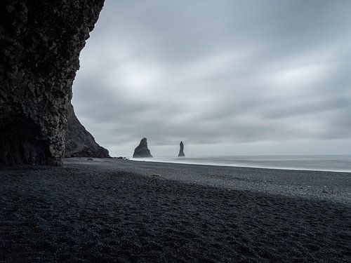 Zwart strand en Reynisdrangar rotsen op een grauwe dag in IJsland