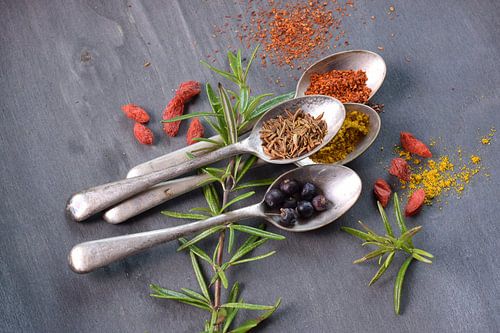 Gewürze oder getrocknete Kräuter auf Löffeln, Stillleben