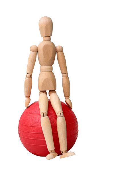 Poupée en bois assise sur un ballon rouge. par Michar Peppenster
