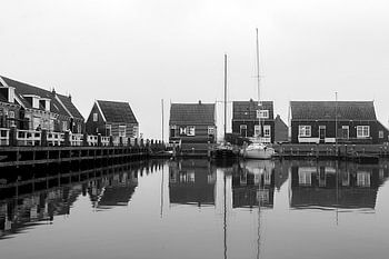 Een weerspiegeling in het water van de haven van Marken