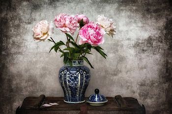 Delfts blauwe vaas met pioenen op een vintage kist