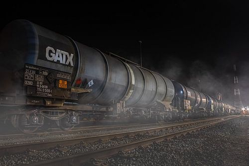 Railroad with freight train on a foggy night in the port of Antwerp