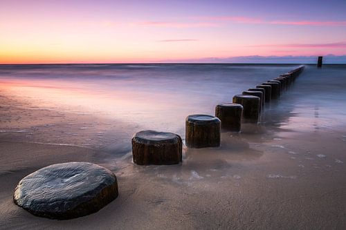 Kribben bij zonsondergang