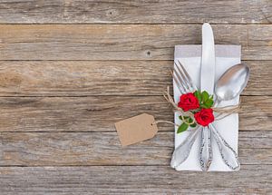 Table de mariage ou de Saint-Valentin avec argenterie arrangée, fleurs de roses rouges et étiquette  sur Alex Winter