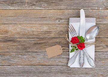 Bruiloft of Valentijn dag tafel setting met gerangschikt zilverwerk, rode rozen bloem en lege tag van Alex Winter