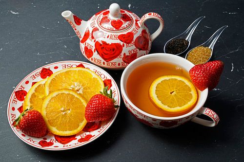 Zwarte thee met aardbei en sinaasappel, versierd met fruit