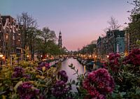 sunset over the canal with the western church in amsterdam