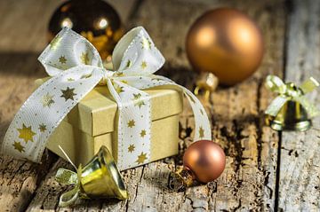 Boîte à cadeaux de Noël avec nœud en ruban, boules dorées sur Alex Winter