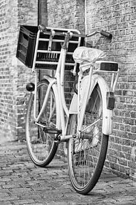 Weißes Retro-Fahrrad gegen eine Ziegelmauer von Tony Vingerhoets