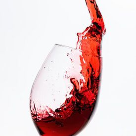 Le vin rouge coule dans le verre à vin sur Roland Brack