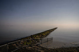 Pier im stillen Wasser des Ems-Dollards, Groningen