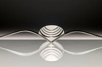 Abstract artistic photo of cutlery, being two forks and a spoon which reflect in the surface.