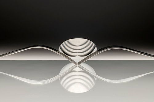 Abstracte artistieke foto van couvert, zijnde twee vorken en een lepel welke spiegelen in het opperv