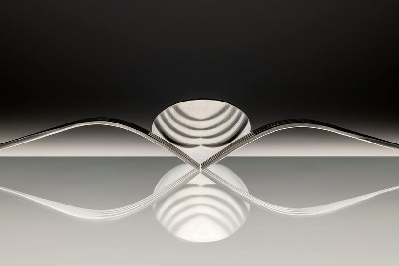 Abstract artistic photo of cutlery, being two forks and a spoon which reflect in the surface. by Tonko Oosterink