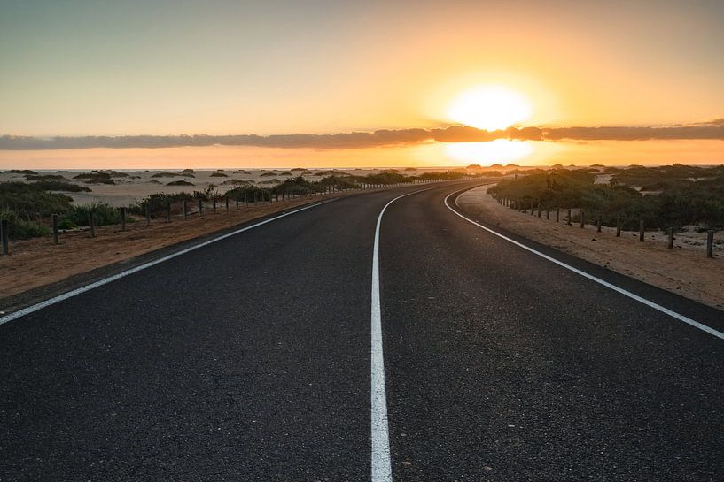 Mooie ochtend op een weg door de duinen. Zonsopgang boven een weg met wolken. Nationa van Fotos by Jan Wehnert