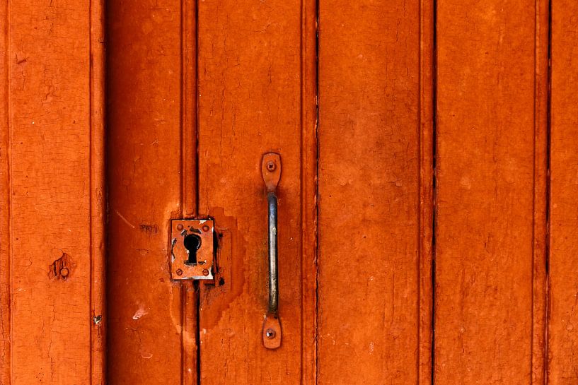 Sleutelgat in roodoranje kleurige deur in het dorp Buis de Baronie in Frankrijk van Cindy Mulder
