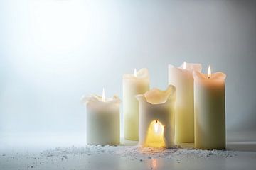 Gruppe weißer Kerzen, eine brennt über dem Kopf in einer warmen Höhle,  von Maren Winter