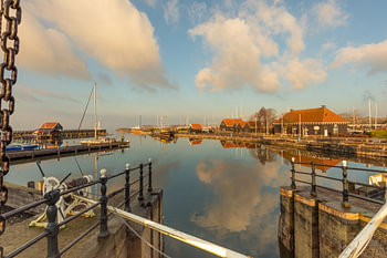 Hafen von Hindeloopen: Schleusenansicht mit Reflexionen von Booten und Wolken