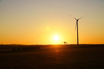 Windturbine bij zonsondergang op een weiland van Martin Köbsch