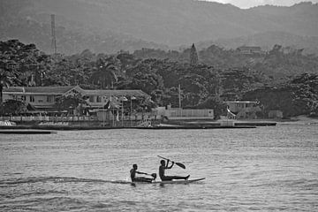 Kinderen op een surfplank voor Ocho Rios / Jamaica