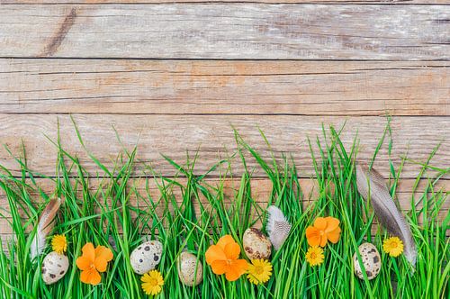 Paaseieren, bloemen, veren en weelderig groen gras
