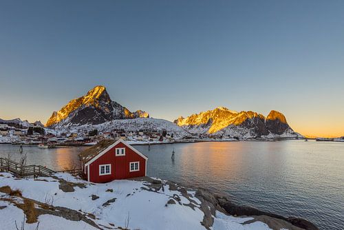 Typische rote Fischerhütte, Rorbu, bei Reine auf den Lofoten Inseln im Winter mit Schnee