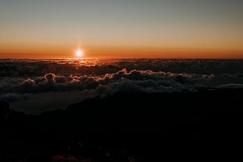 Sunrise above the clouds atop a mountain peak