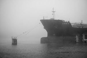 Im Nebel an der Mole vertäute Schiffe