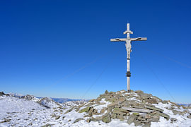 Kruis op de top van de met sneeuw bedekte berg Greim, Stiermarken, Oostenrijk. van Tomherkules