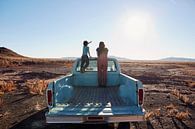 SA12501548 Frau und Kind auf einem Pickup in der Wüste von BeeldigBeeld Food & Lifestyle Miniaturansicht