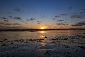 Wasserspiegelung der Sonne am Strand