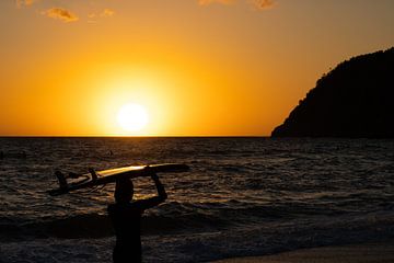 Surfer tijdens de zonsondergang van Stef Heijenk