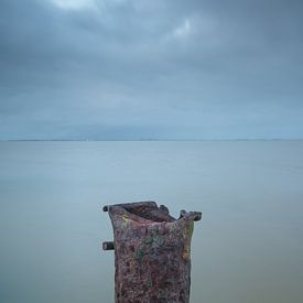 Rusty pole in the water, minimalist by Rick Goede