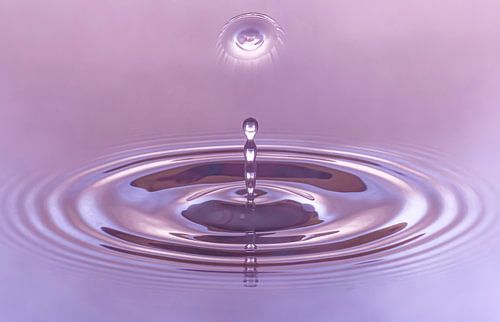 mehrere Wassertropfen treten aus dem Wasser aus