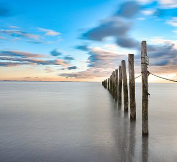 Poteaux à longue exposition au coucher du soleil sur la mer sur Marjolein van Middelkoop