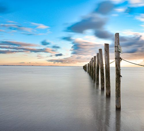 Long exposure poles in sea sunset