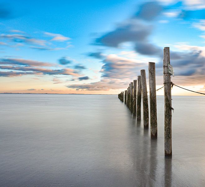 Long exposure palen in zee zonsondergang van Marjolein van Middelkoop