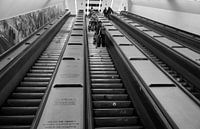 Black and white photograph of people on the escalator