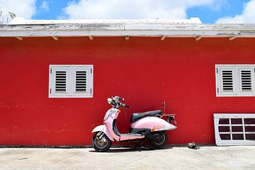 Roze Vespa scooter geparkeerd voor felrode muur in de zon van Studio LE-gals