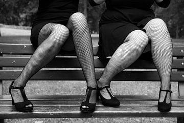 Zwei sexy Frauen, die schwarze Netzstrümpfe und hochhackige Schuhe tragen v...