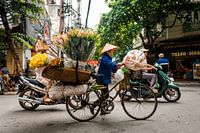 Vrouw met fiets vol met bloemen in Hanoi Vietnam.