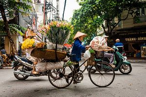 Frau mit einem Fahrrad voll von Blumen in Hanoi Vietnam von Niels Rurenga