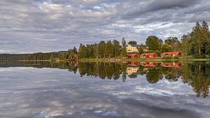 Typique de la Suède - Les maisons en bois rouge et les arbres se reflètent dans l'eau