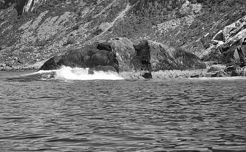 Norwegen am Fjord, Gischt an den Felsen. Wasser spritzt gegen die Steine. Küstenlandschaft.