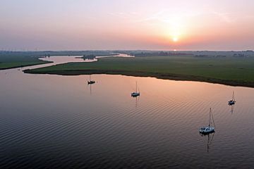 Zeilboten voor anker op De Morra in Friesland Nederland bij zonsondergang van Eye on You
