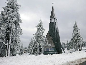 De kerk van Rogla in de Sloveens Alpen in een besneeuwd landschap. van Gert Bunt