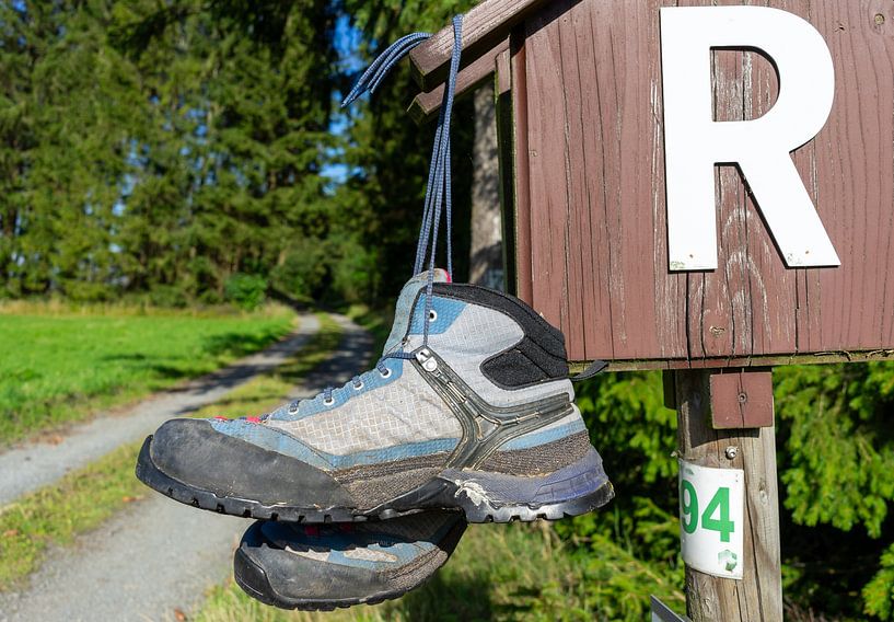 Une paire de chaussures de randonnée sur un panneau du Rennsteig dans la forêt de Thuringe par Animaflora PicsStock
